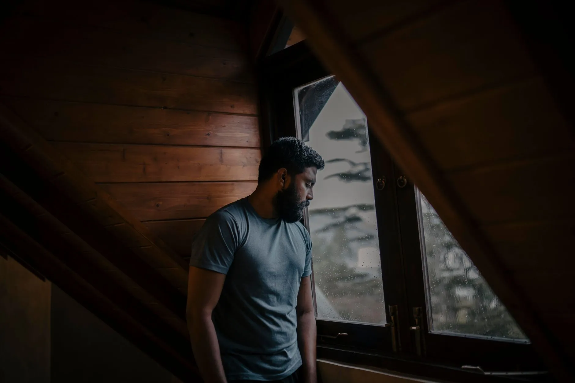 Calm person sitting by a window, reflecting quietly during a moment of reassurance