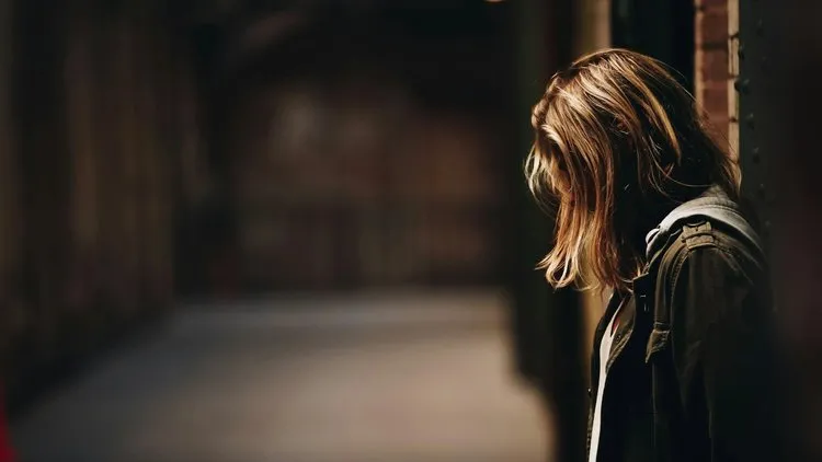 Person sitting peacefully in nature, symbolising recovery and calm after trauma